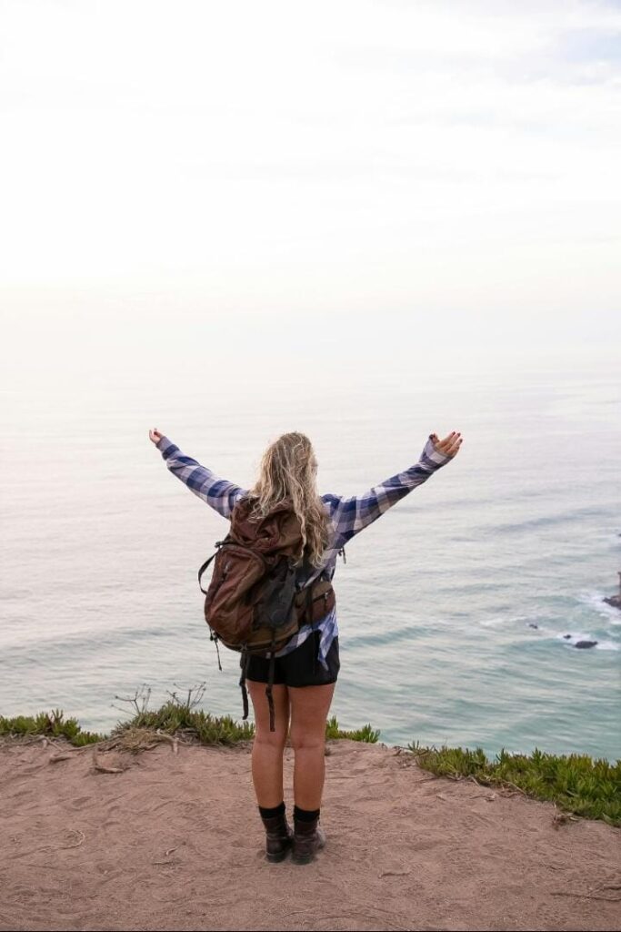 “Woman with open arms enjoying nature and freedom on a mountain”